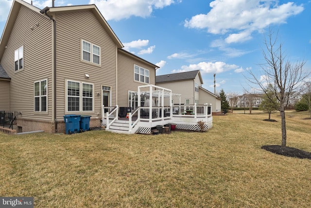 rear view of house featuring a lawn and a wooden deck