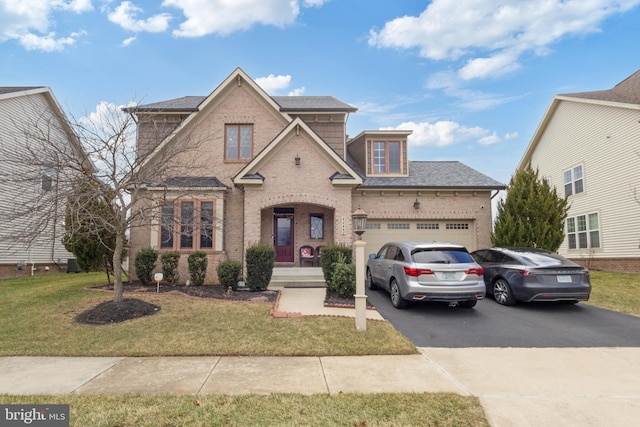 traditional-style house featuring aphalt driveway, an attached garage, brick siding, and a front yard