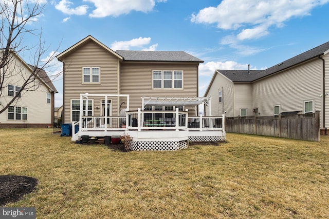 back of property with a yard, fence, a wooden deck, and a pergola