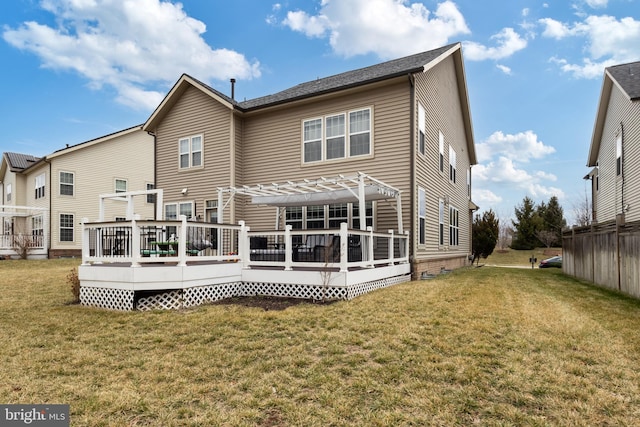 rear view of house with a lawn and a deck