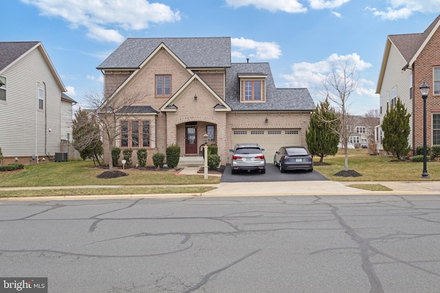 traditional-style house with driveway, a shingled roof, a front lawn, central air condition unit, and brick siding