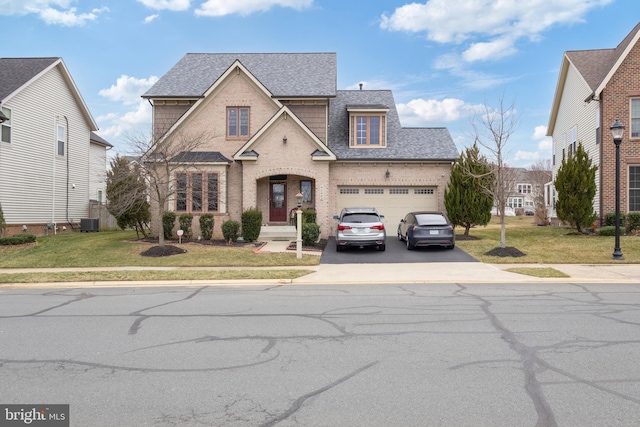 traditional home with cooling unit, a front yard, driveway, and roof with shingles