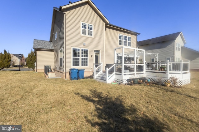 back of property with a lawn, entry steps, a wooden deck, and central AC