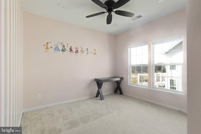 spare room featuring carpet flooring, visible vents, baseboards, and ceiling fan