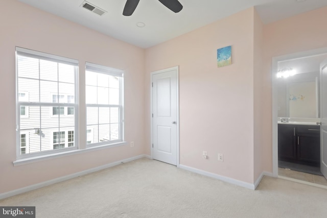 interior space with visible vents, baseboards, light colored carpet, and a ceiling fan