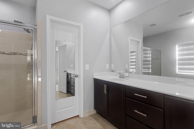 bathroom with vanity, a shower stall, visible vents, and tile patterned floors