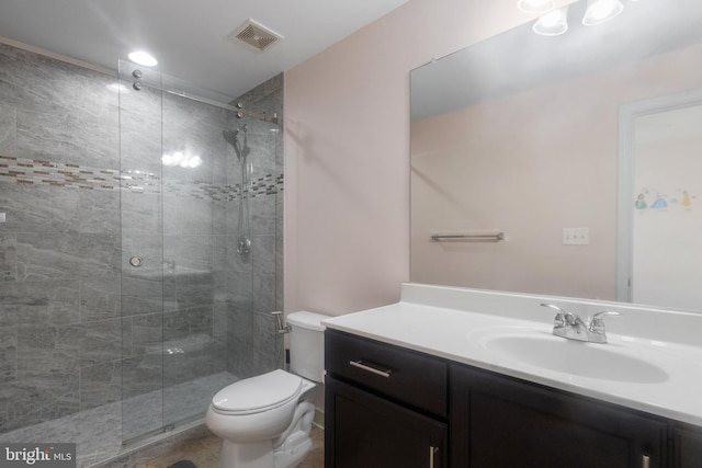 bathroom with visible vents, toilet, a stall shower, and vanity