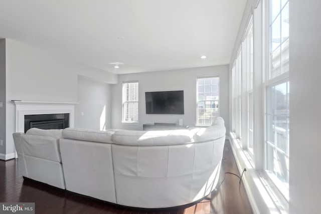 living room with recessed lighting, dark wood-type flooring, and a fireplace