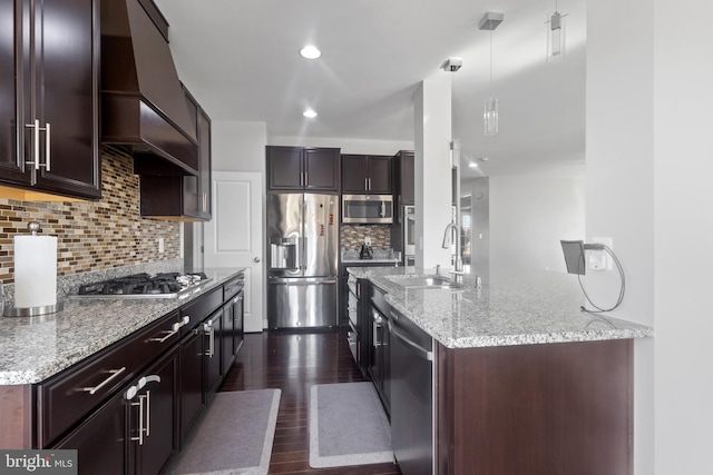 kitchen with dark wood-style flooring, a sink, stainless steel appliances, dark brown cabinetry, and custom range hood