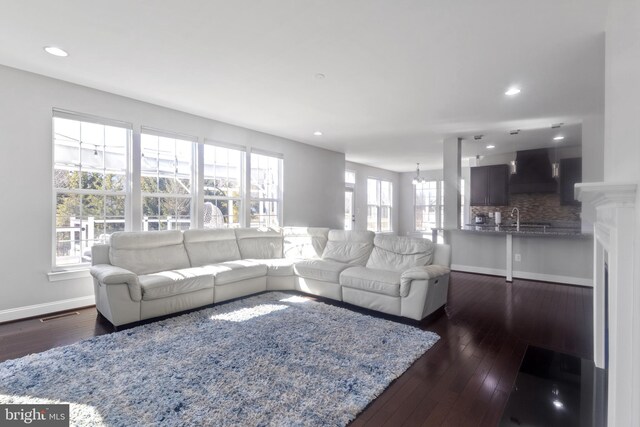 living area featuring recessed lighting, dark wood-type flooring, and baseboards