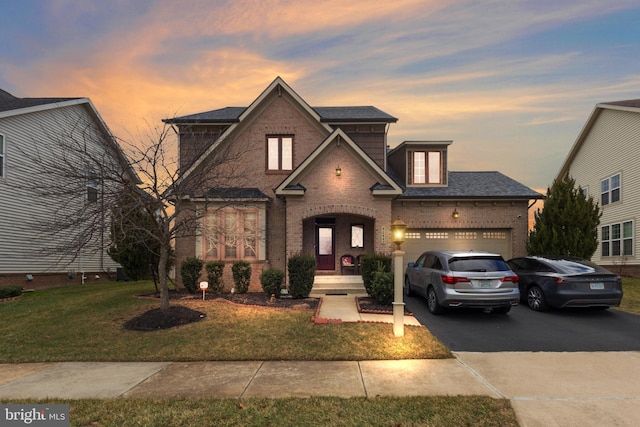 view of front of house featuring aphalt driveway, brick siding, a garage, and a front yard