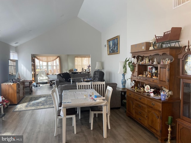 dining area featuring visible vents, high vaulted ceiling, and wood finished floors