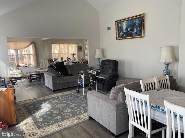 living room featuring visible vents, high vaulted ceiling, and wood finished floors