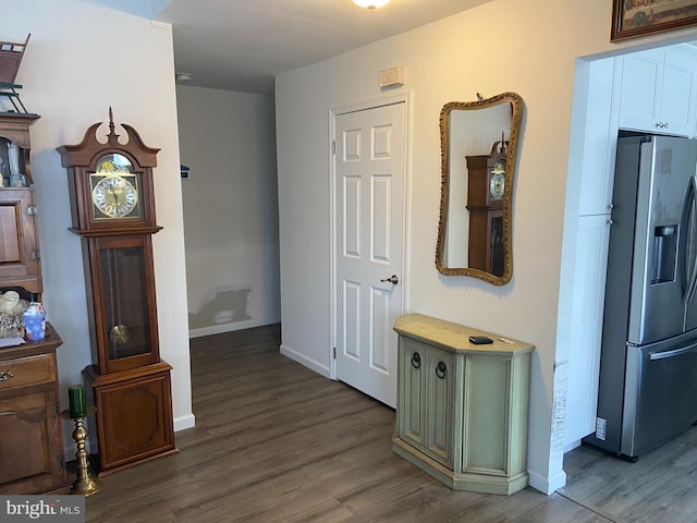 hallway featuring wood finished floors and baseboards