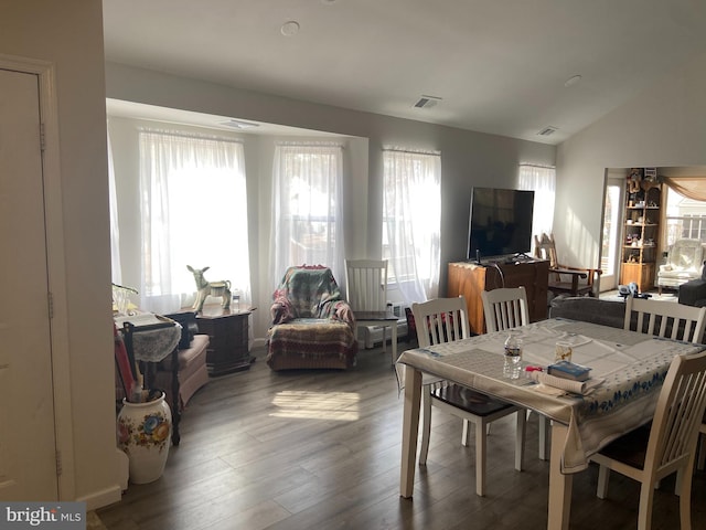 dining area with visible vents, plenty of natural light, wood finished floors, and vaulted ceiling