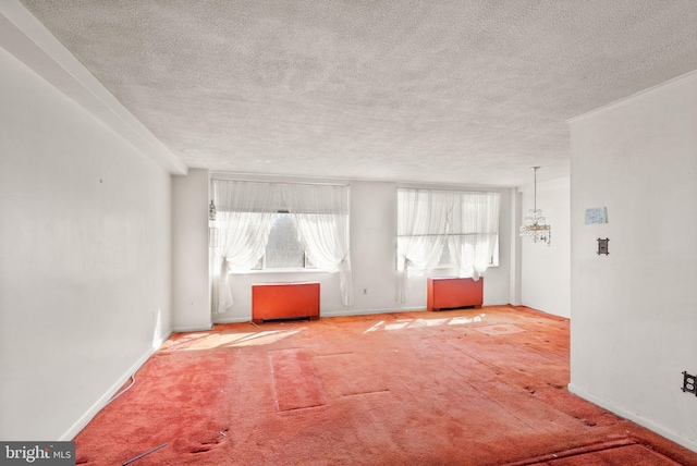 carpeted empty room featuring baseboards, a notable chandelier, and a textured ceiling