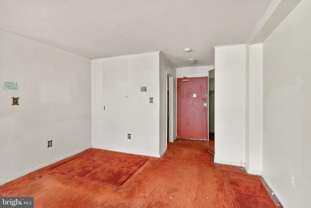 spare room featuring baseboards and a textured ceiling