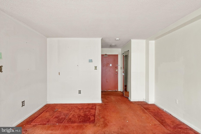 spare room featuring a textured ceiling and baseboards