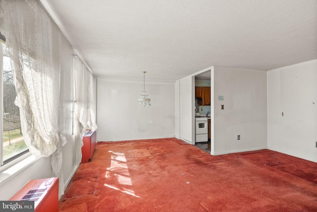 spare room with a textured ceiling and light carpet