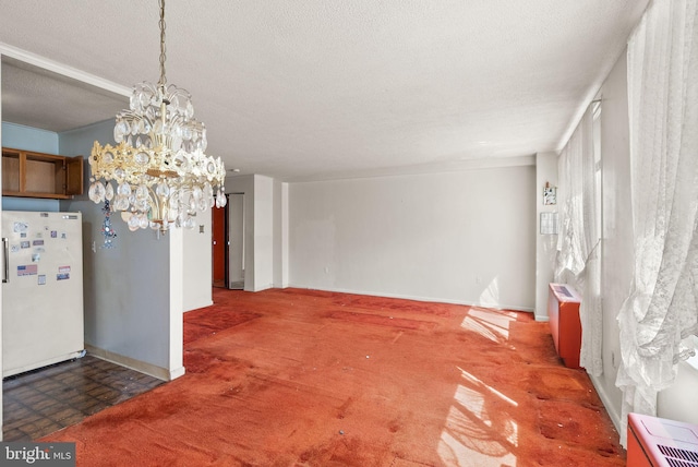 unfurnished dining area with baseboards, a textured ceiling, an inviting chandelier, and carpet