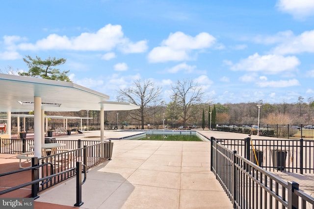 view of patio with a community pool and fence