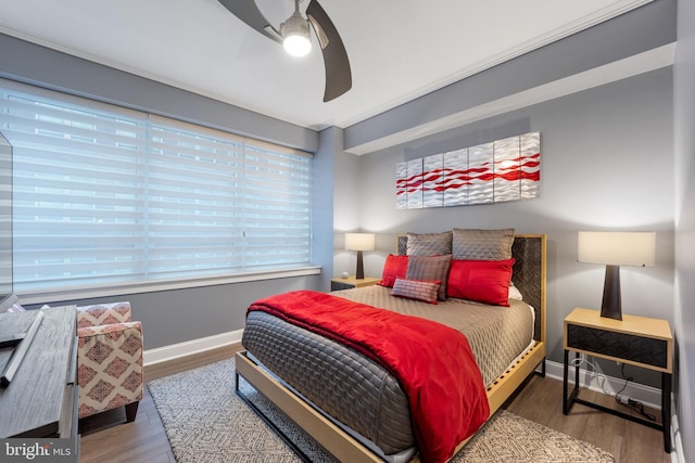 bedroom featuring wood finished floors, baseboards, and ceiling fan