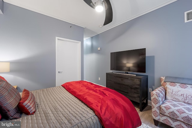 bedroom featuring wood finished floors, ceiling fan, and ornamental molding