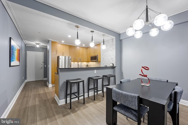 dining area featuring light wood finished floors, recessed lighting, baseboards, and ornamental molding