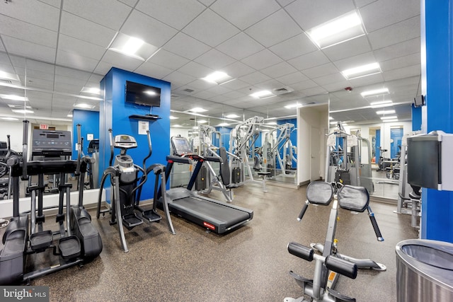 gym featuring baseboards, visible vents, and a drop ceiling