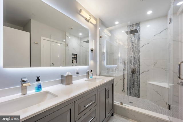 bathroom with a marble finish shower, marble finish floor, double vanity, and a sink