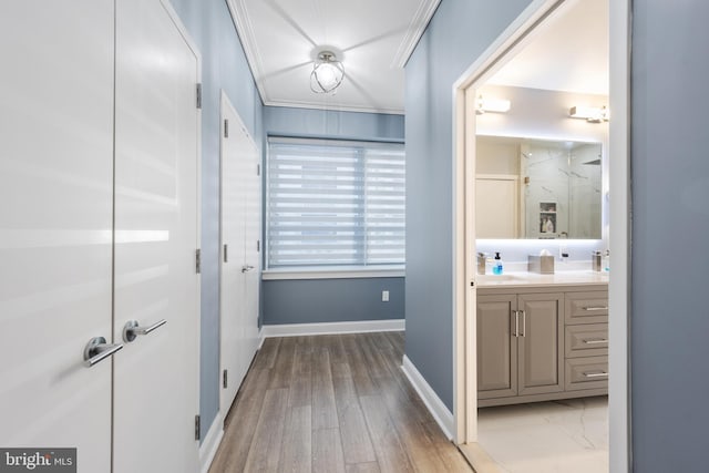 bathroom featuring wood finished floors, crown molding, a shower, baseboards, and vanity