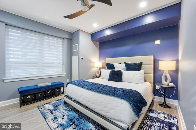 bedroom featuring a ceiling fan, wood finished floors, visible vents, and baseboards