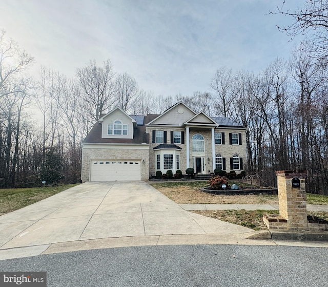 greek revival house featuring concrete driveway and an attached garage