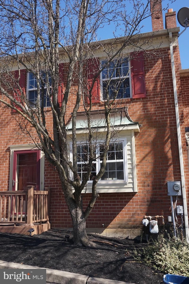 exterior space featuring brick siding and a chimney