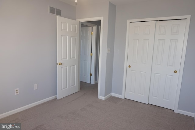 unfurnished bedroom with carpet, visible vents, a closet, and baseboards