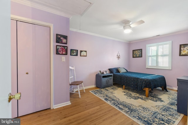 bedroom featuring attic access, crown molding, baseboards, and wood finished floors