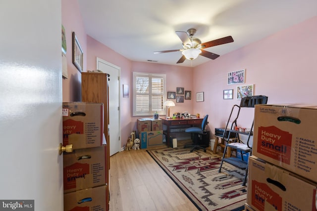 office space featuring visible vents, light wood-style floors, and a ceiling fan