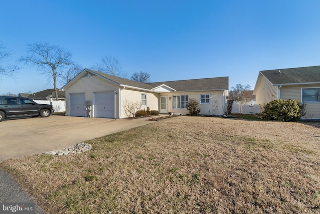 ranch-style home featuring a front yard, concrete driveway, and an attached garage