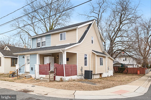 view of front of home with entry steps, cooling unit, and fence