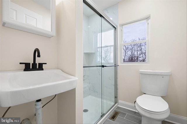 full bathroom featuring baseboards, visible vents, a marble finish shower, a sink, and toilet