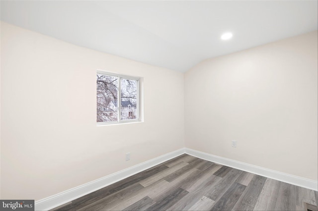 unfurnished room featuring recessed lighting, baseboards, lofted ceiling, and dark wood-style flooring