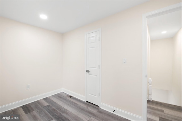 clothes washing area with recessed lighting, baseboards, and wood finished floors