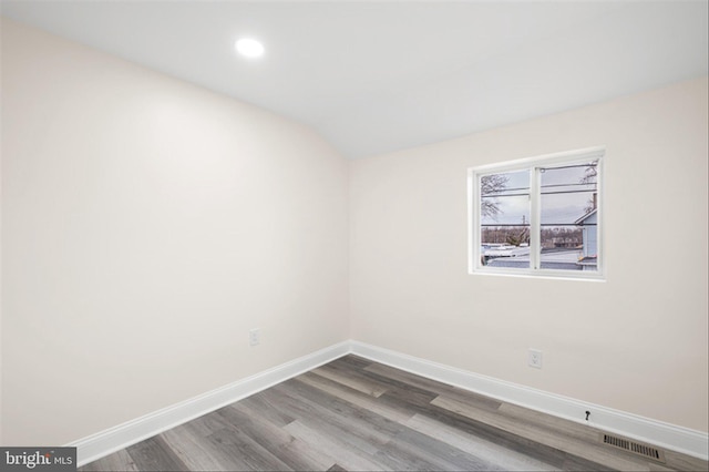 empty room featuring wood finished floors, recessed lighting, baseboards, and visible vents