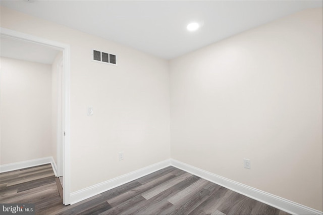 spare room featuring dark wood finished floors, visible vents, recessed lighting, and baseboards