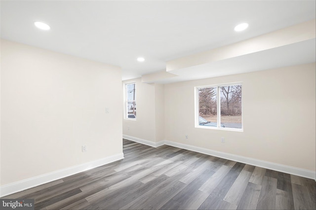 empty room featuring recessed lighting, baseboards, and dark wood-style flooring