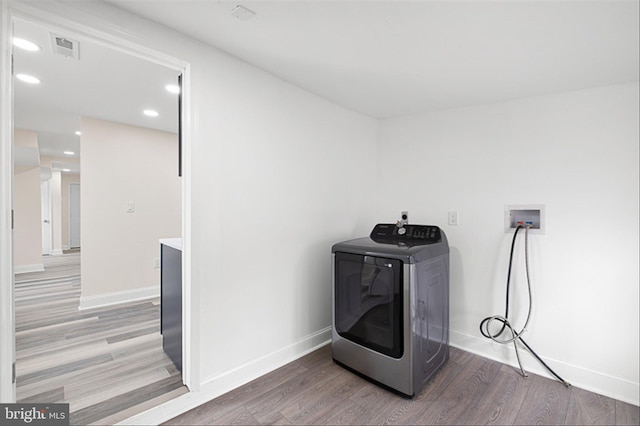 clothes washing area with laundry area, washer / dryer, baseboards, and light wood-style floors