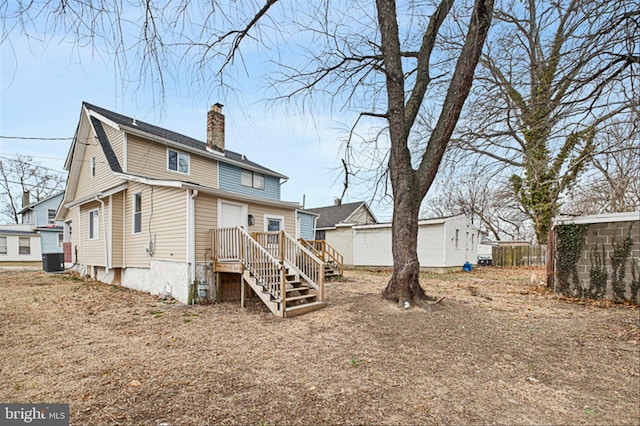 back of property featuring cooling unit and a chimney