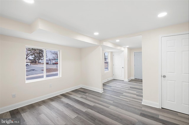 unfurnished room with recessed lighting, wood finished floors, and baseboards