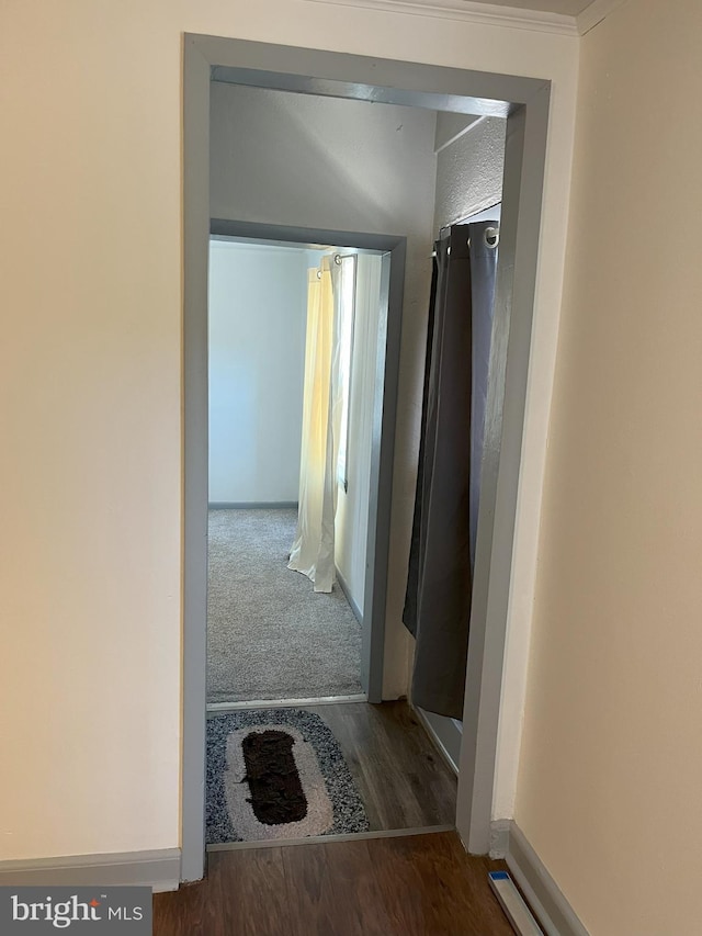 hallway with wood finished floors and baseboards