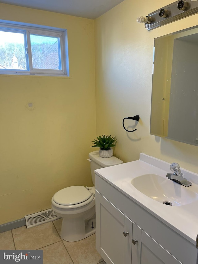 half bath with tile patterned floors, visible vents, toilet, and vanity